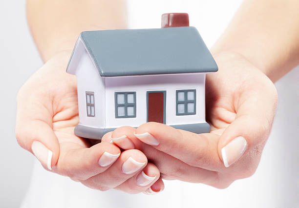 Mãos Segurando uma Casa -segurança e estabilidade financeira do fundo de emergência