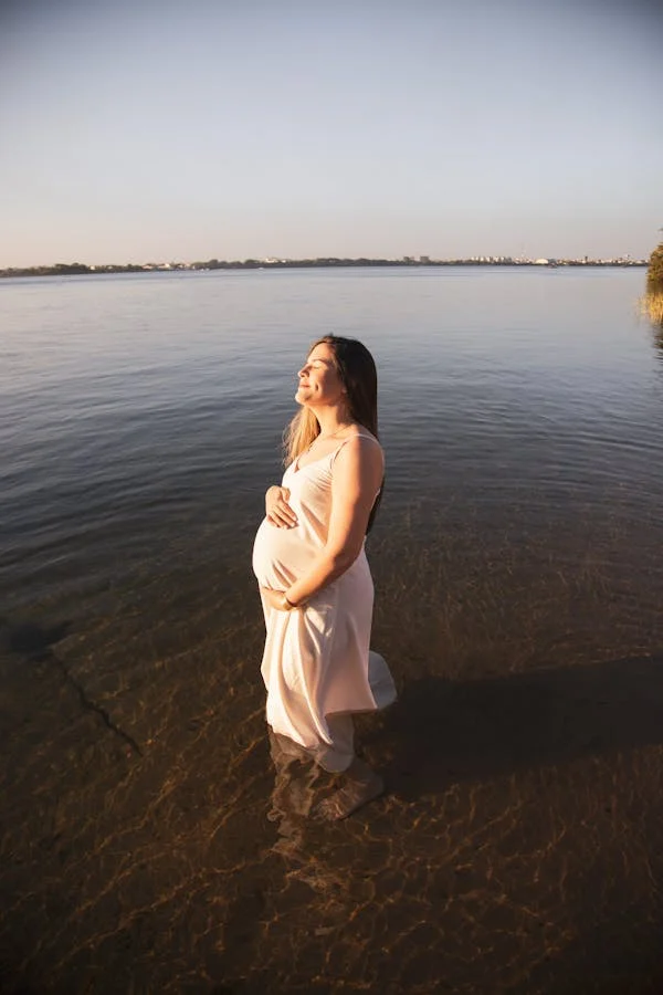 mulher grávida em um momento de paz ao ar livre, com uma expressão de calma e confiança.